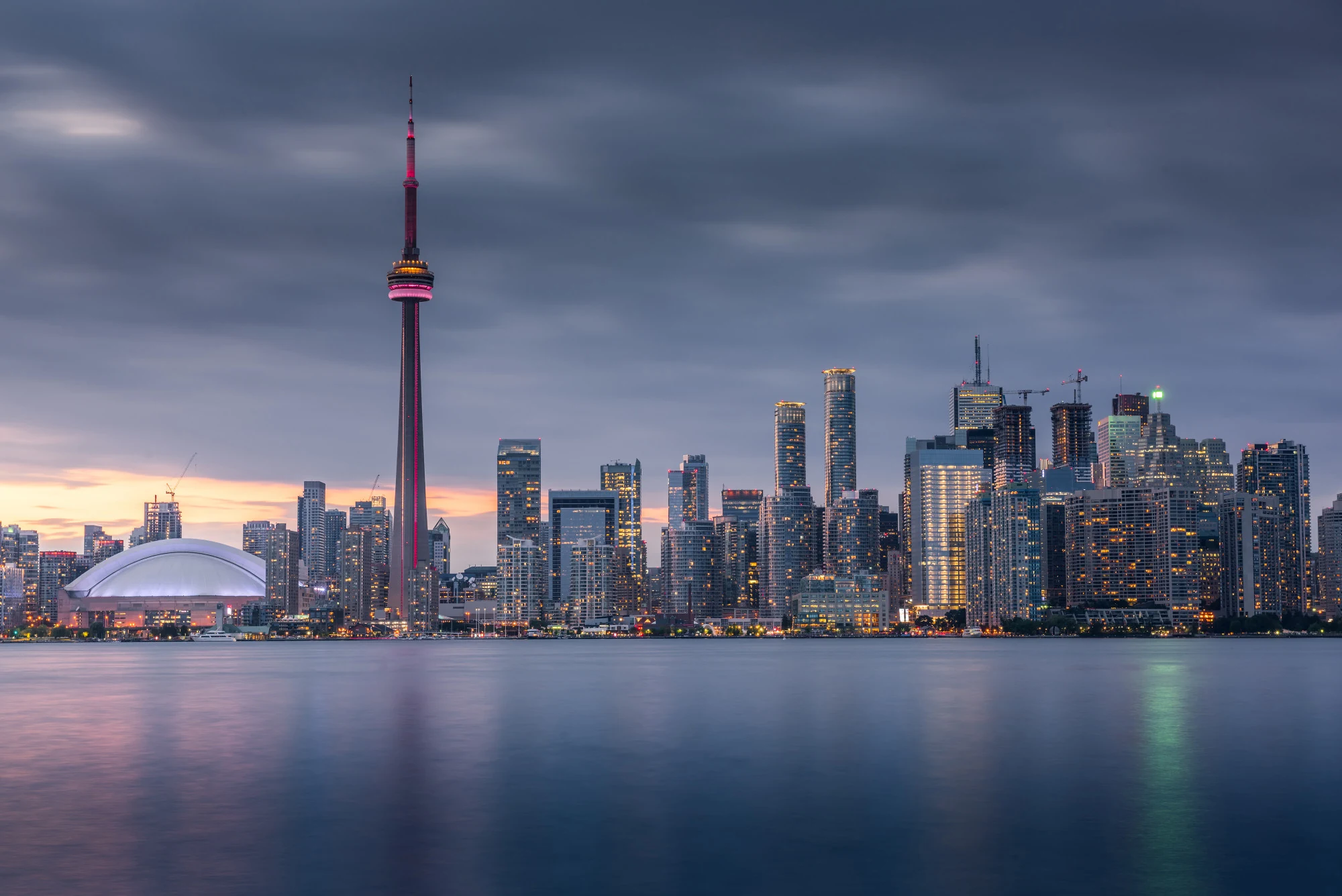 The Toronto skyline and CN Tower at dusk, seen across the harbour